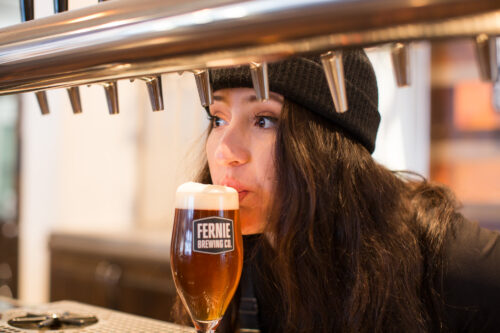Woman sipping freshly poured beer.