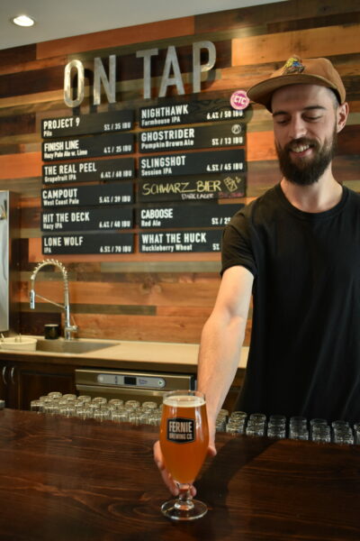 Man serving a beer at the Fernie Brewing Co. Tasting Room.