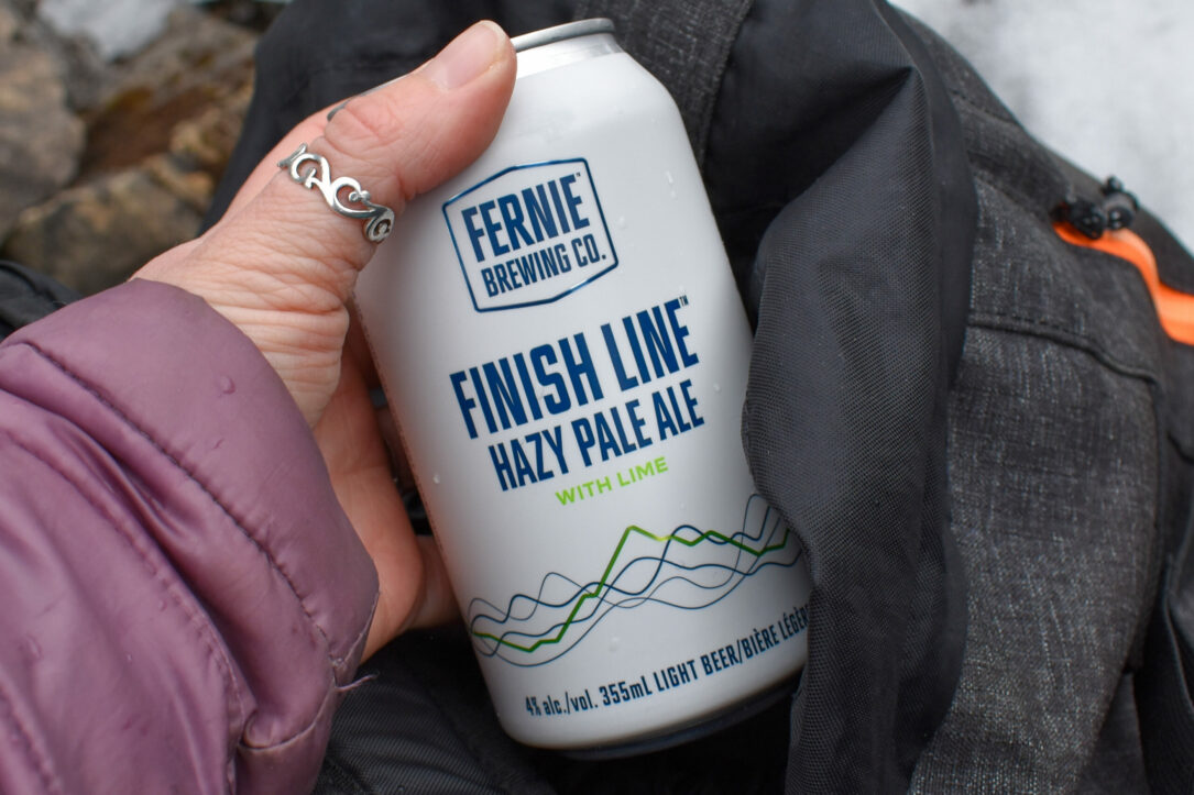 Womens hand holding Finish Line Hazy Pale Ale can