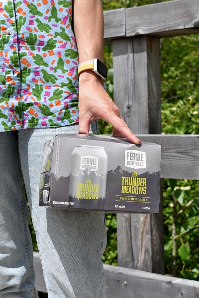 a hand holding a 6pack of thunder meadows ipa