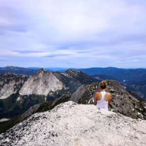 Hiker sitting on the summit of a mountain