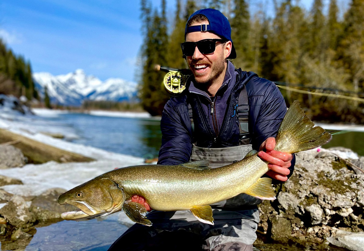 Patrick having caught a big fish on a river.