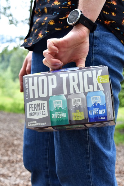 a hand holding a hop trick 6 pack