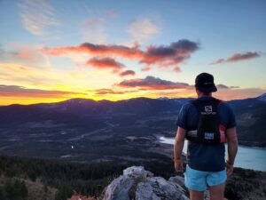 Ian overlooking a sunset while out on a mountain run