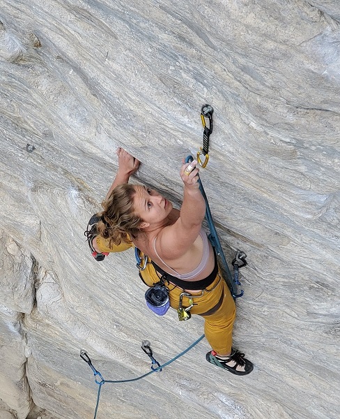 A woman rockclimbing up a rock face