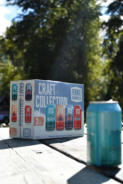 a can of beer and pack of craft collection on a table in the sun