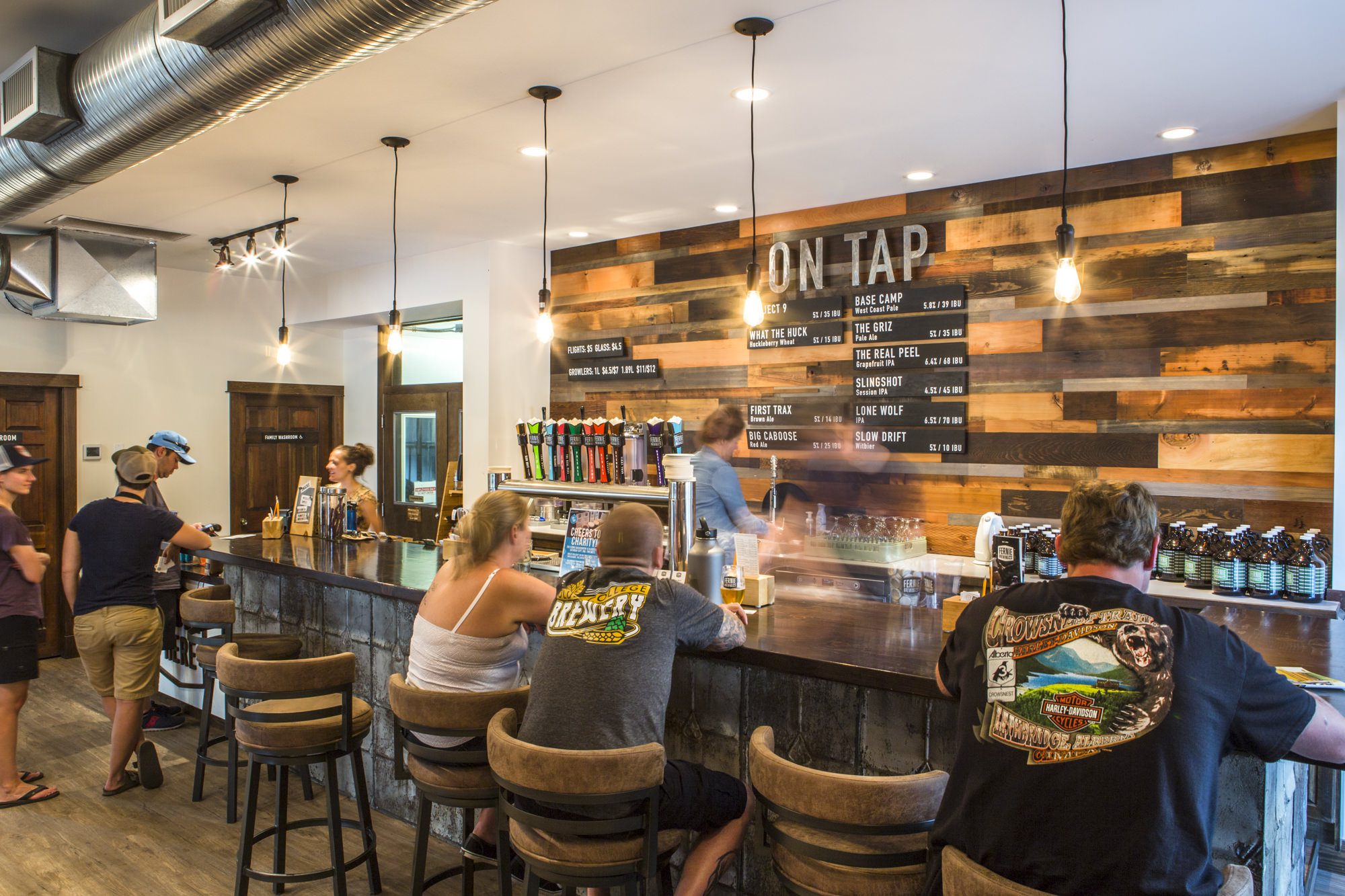 A group of people sitting at the bar in the Fernie Brewing Co. Tasting Room.