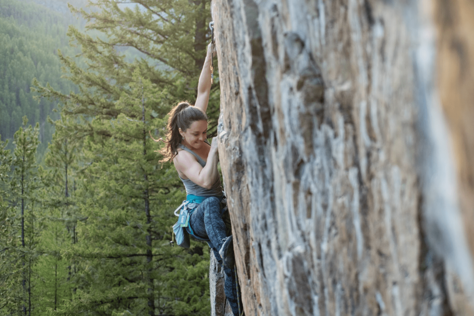 A woman bouldering outdoors.