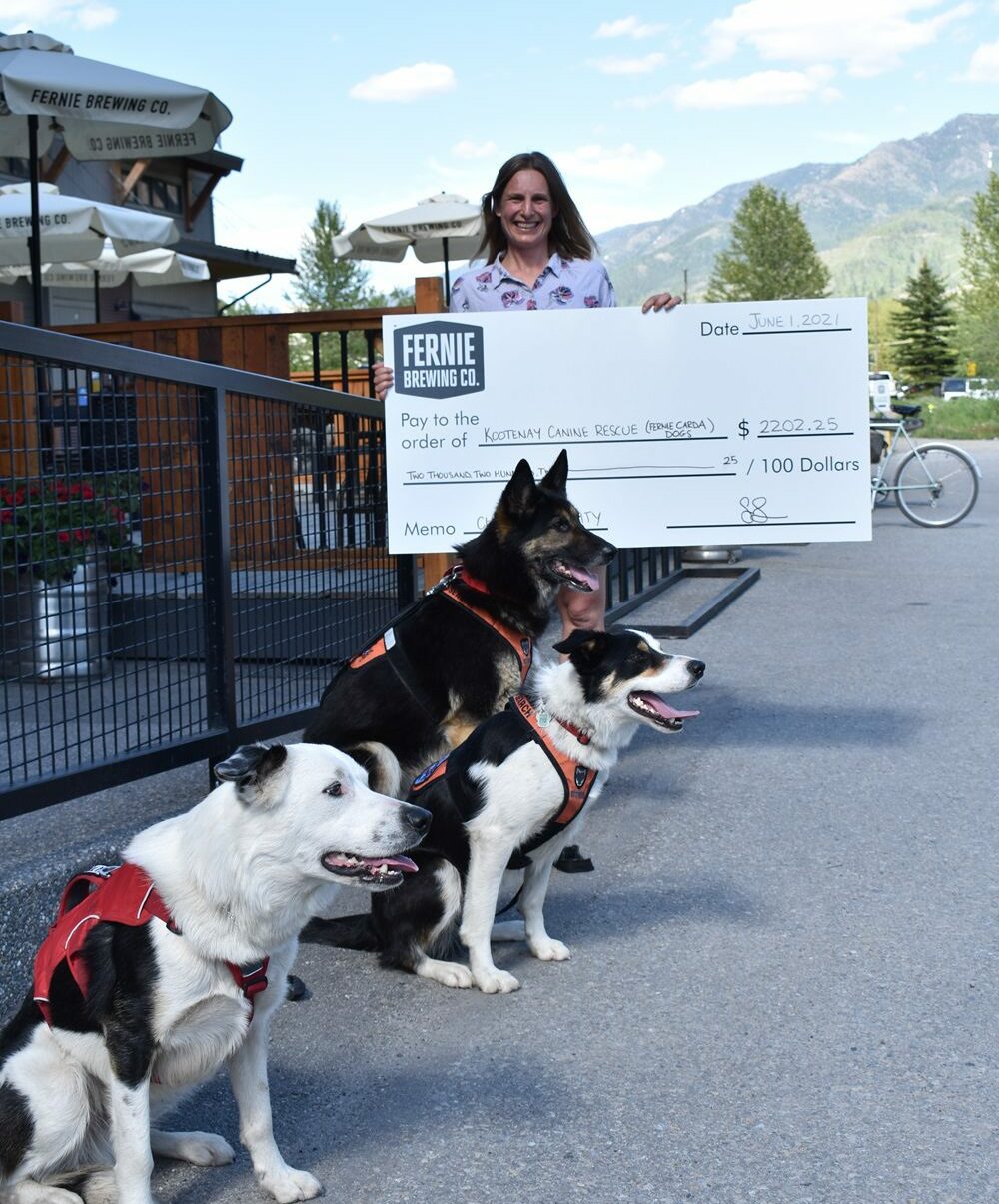 woman with large cheque and dogs